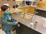 student getting started and exploring with glue to secure vertical sections of a maze